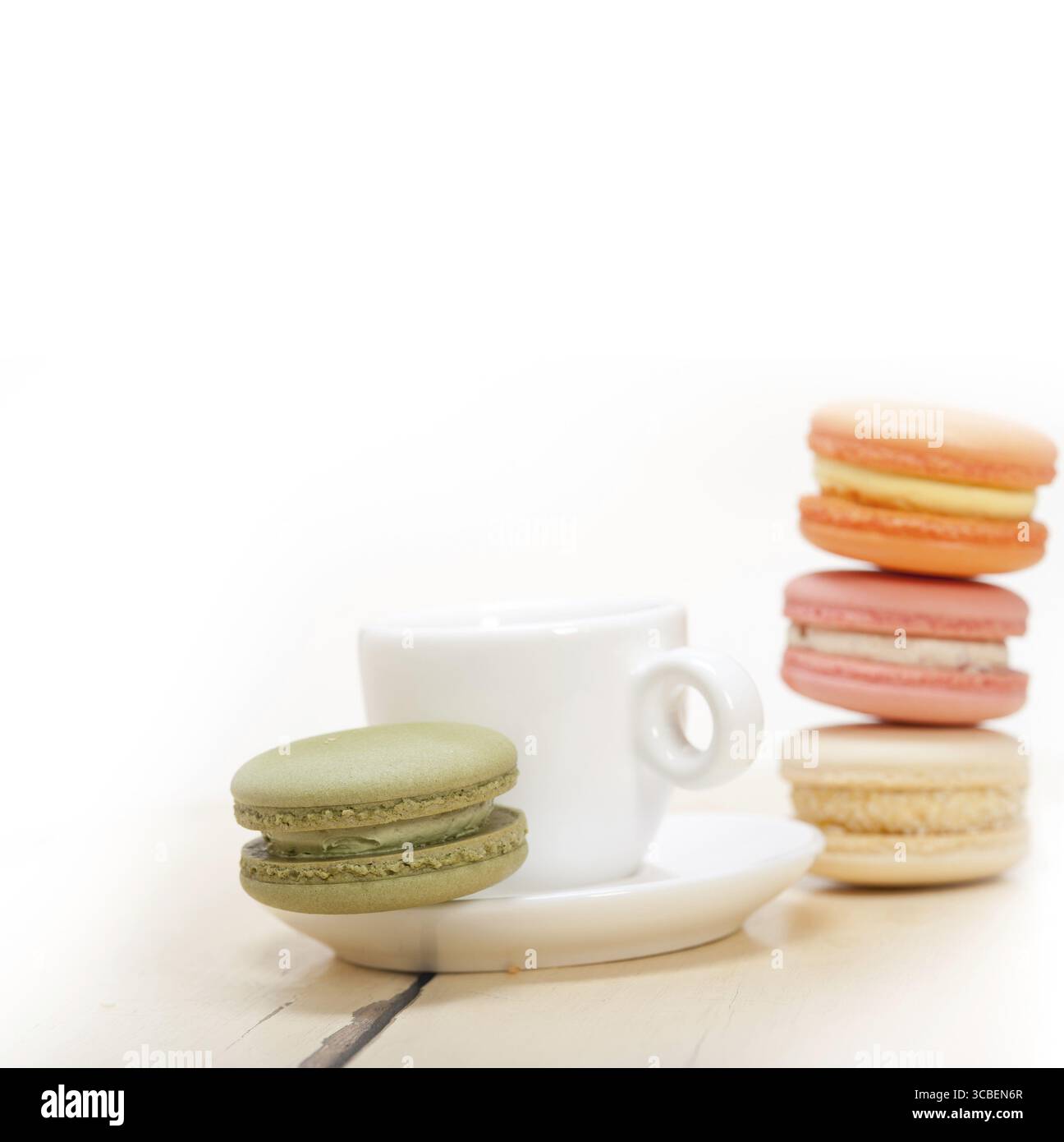 Macarons colorés avec café expresso sur table en bois blanc Banque D'Images