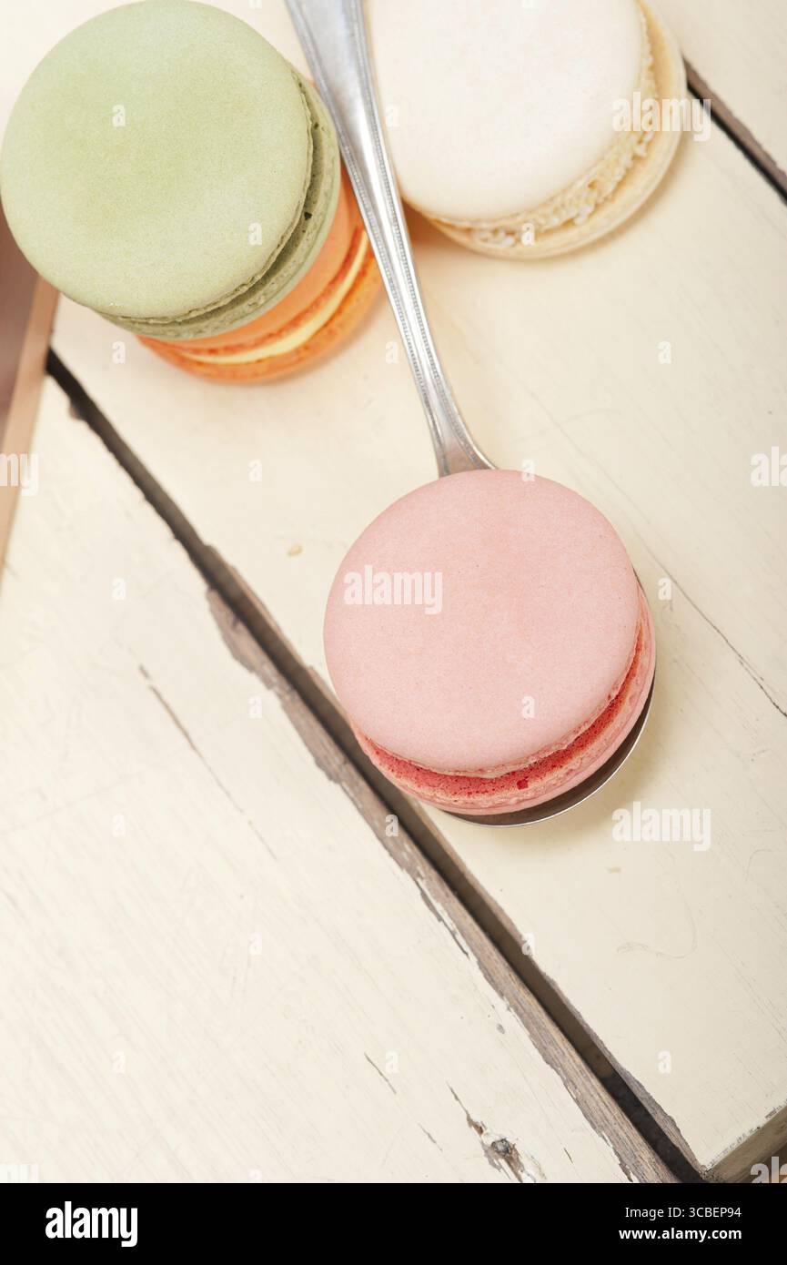 Macarons français colorés sur une table en bois rustique blanc Banque D'Images