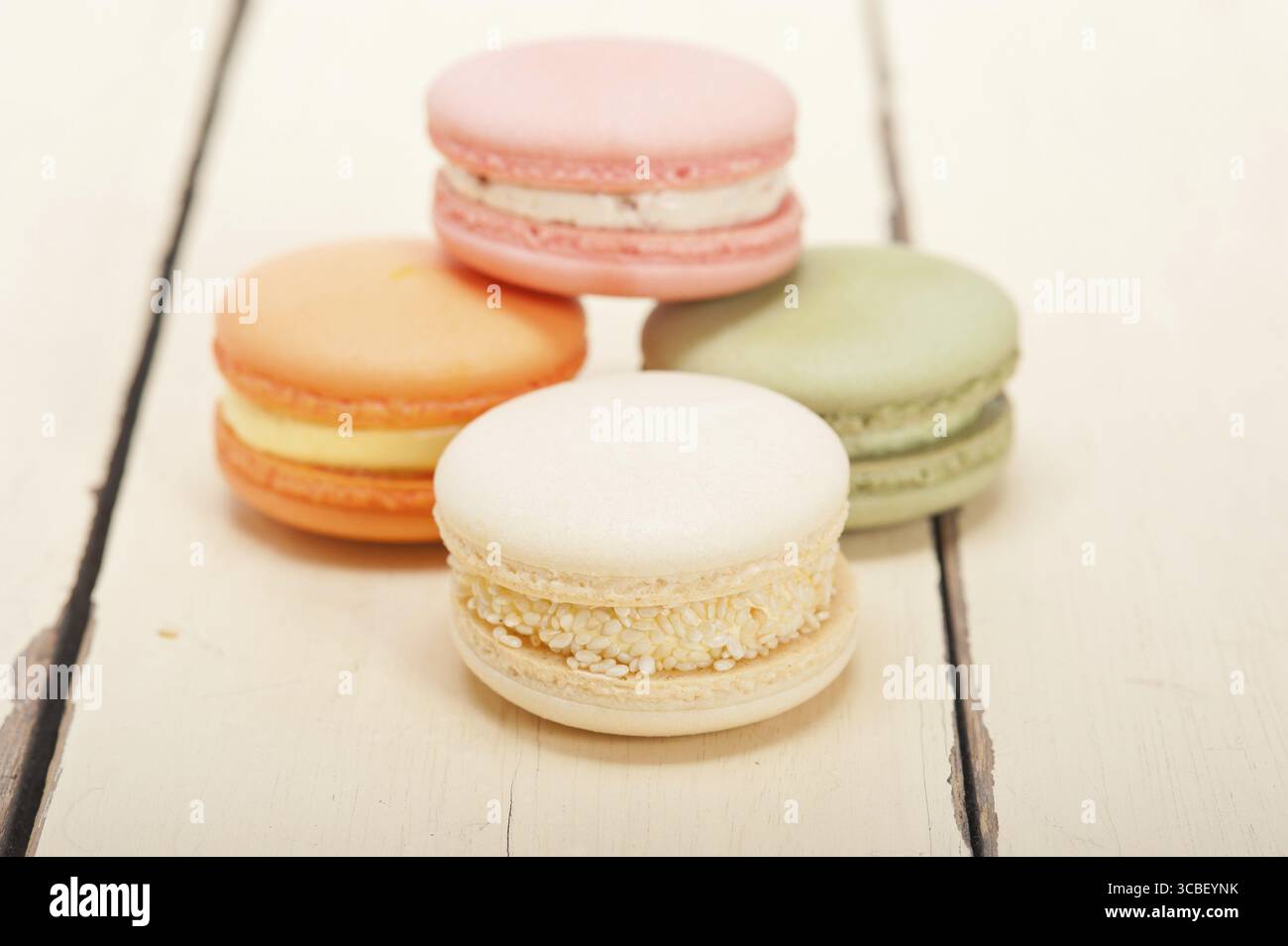 Macarons français colorés sur une table en bois rustique blanc Banque D'Images
