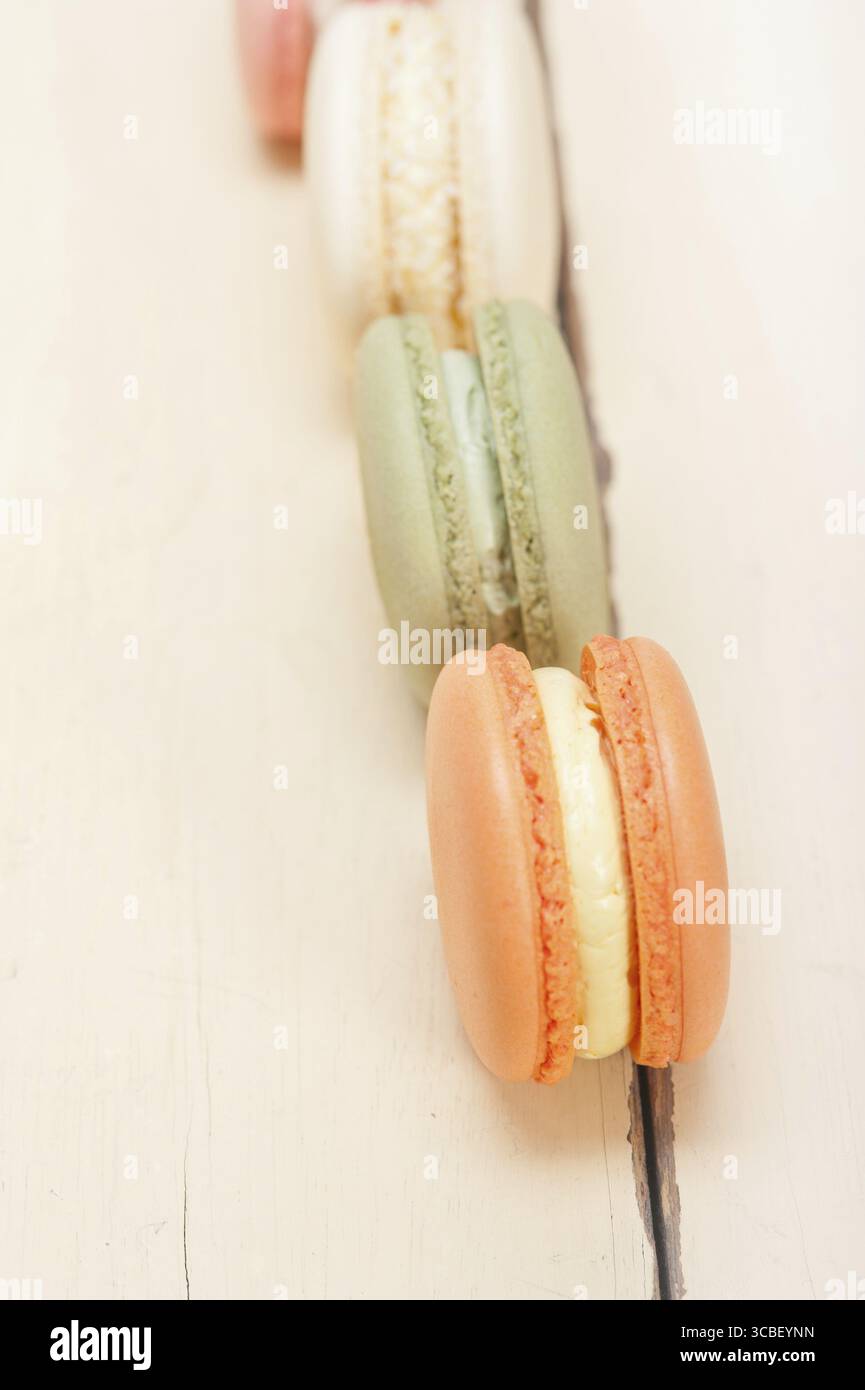 Macarons français colorés sur une table en bois rustique blanc Banque D'Images