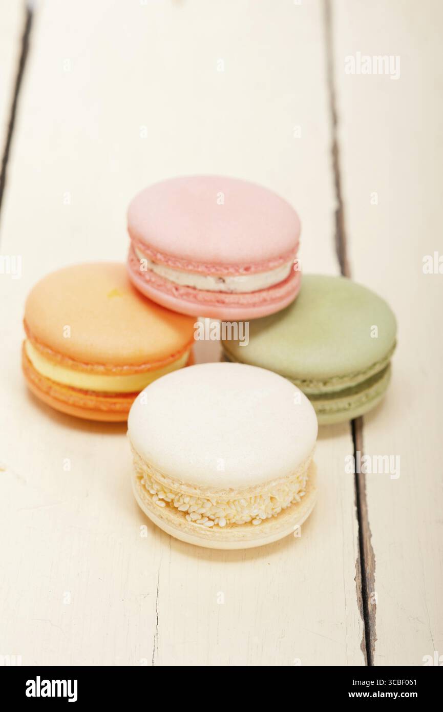 Macarons français colorés sur une table en bois rustique blanc Banque D'Images