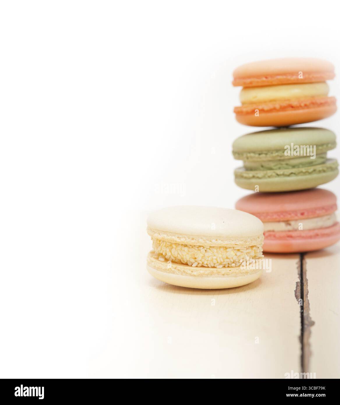 Macarons français colorés sur une table en bois rustique blanc Banque D'Images