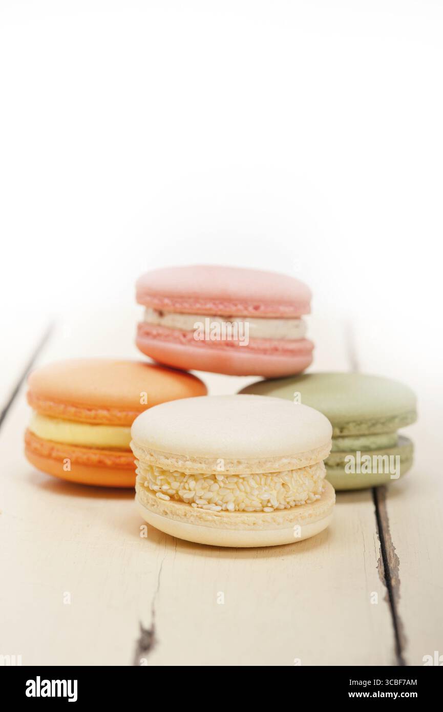 Macarons français colorés sur une table en bois rustique blanc Banque D'Images
