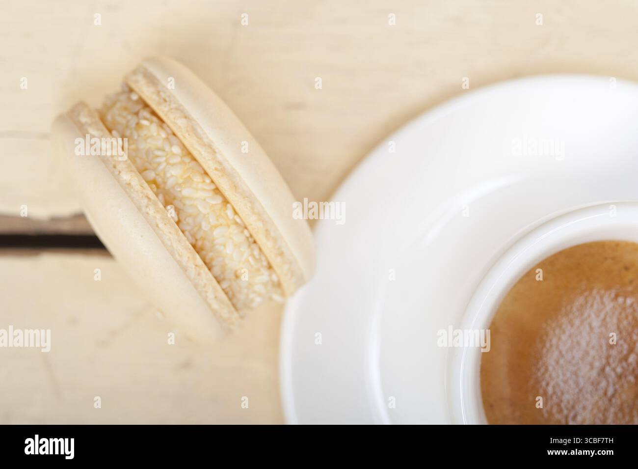 Macarons colorés avec café expresso sur table en bois blanc Banque D'Images