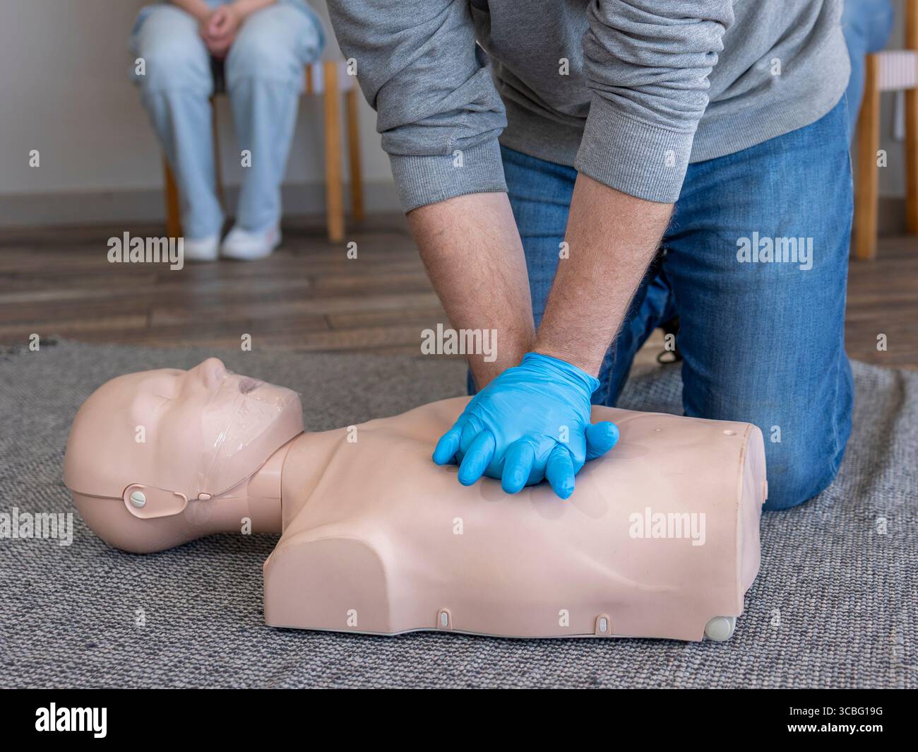 Gros plan des mains. Étudiant de sexe masculin pratiquant la technique de compression thoracique appropriée sur un mannequin de réanimation cardio-respiratoire de base (BLS) au cours d'une formation aux premiers soins cl Banque D'Images