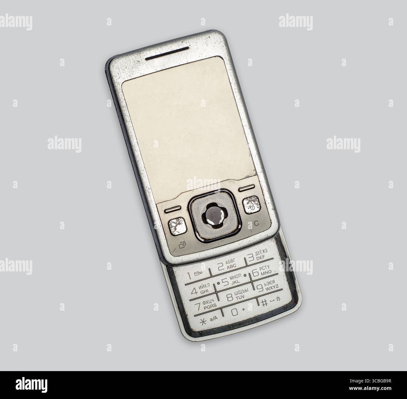 Vieux téléphone à clapet avec boutons sur fond gris, isolé. Ancien téléphone portable usagé. Concept d'utilisation et de recyclage des déchets électroniques. Vieux gadgets. Banque D'Images