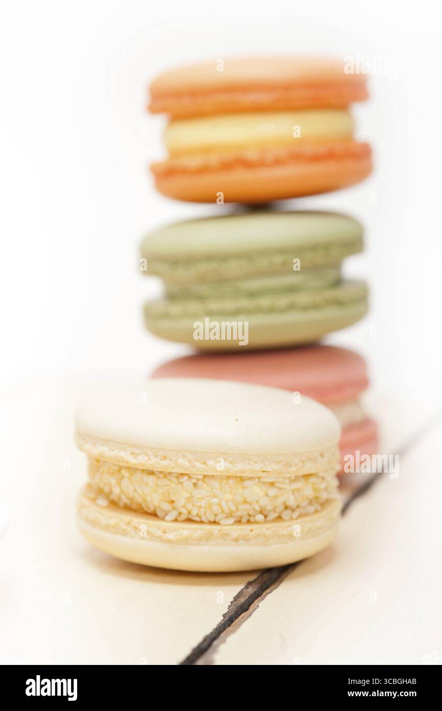 Macarons français colorés sur une table en bois rustique blanc Banque D'Images