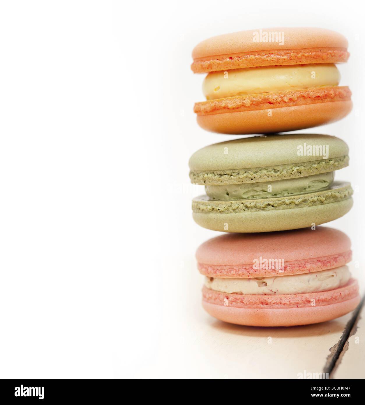 Macarons français colorés sur une table en bois rustique blanc Banque D'Images