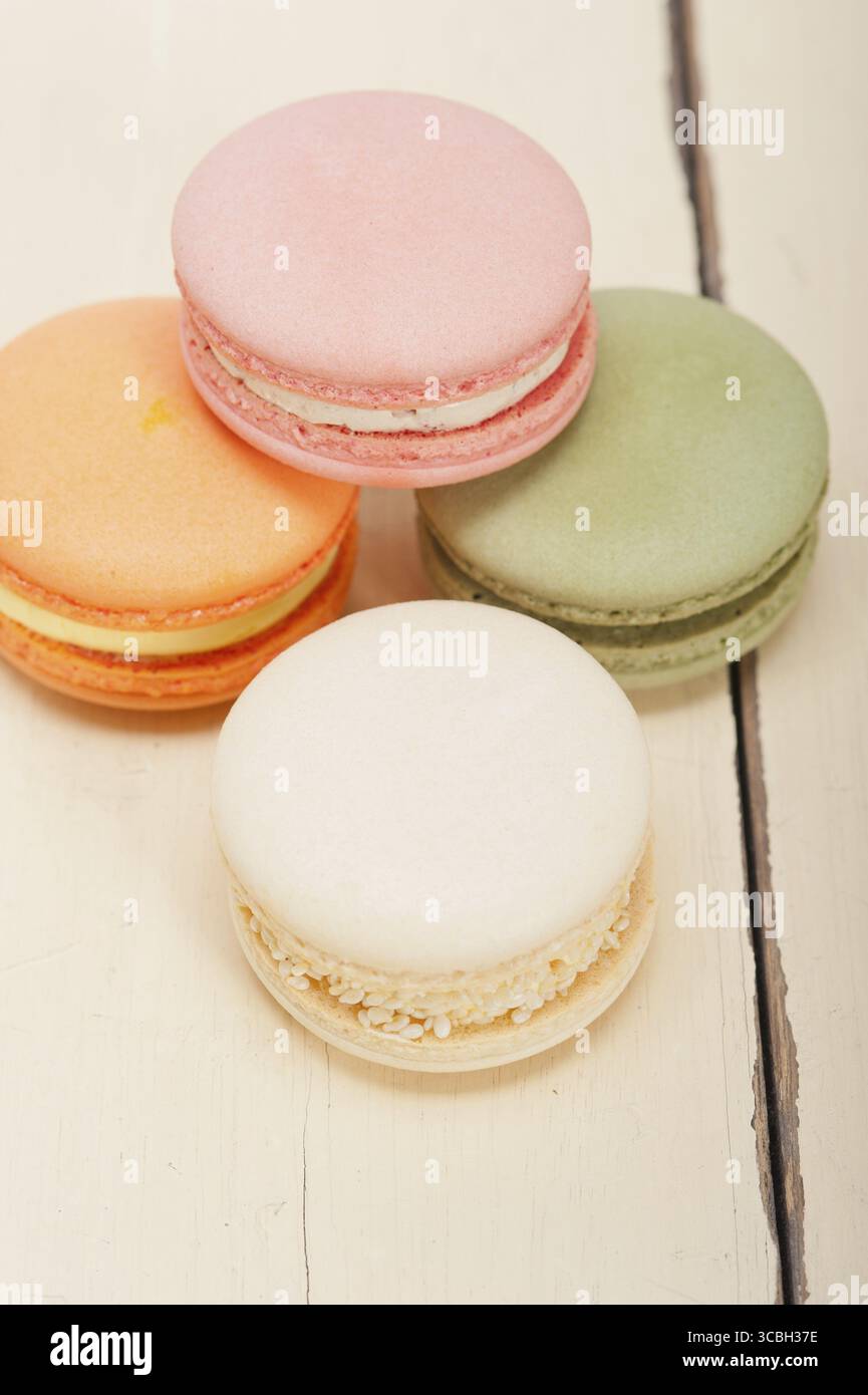 Macarons français colorés sur une table en bois rustique blanc Banque D'Images