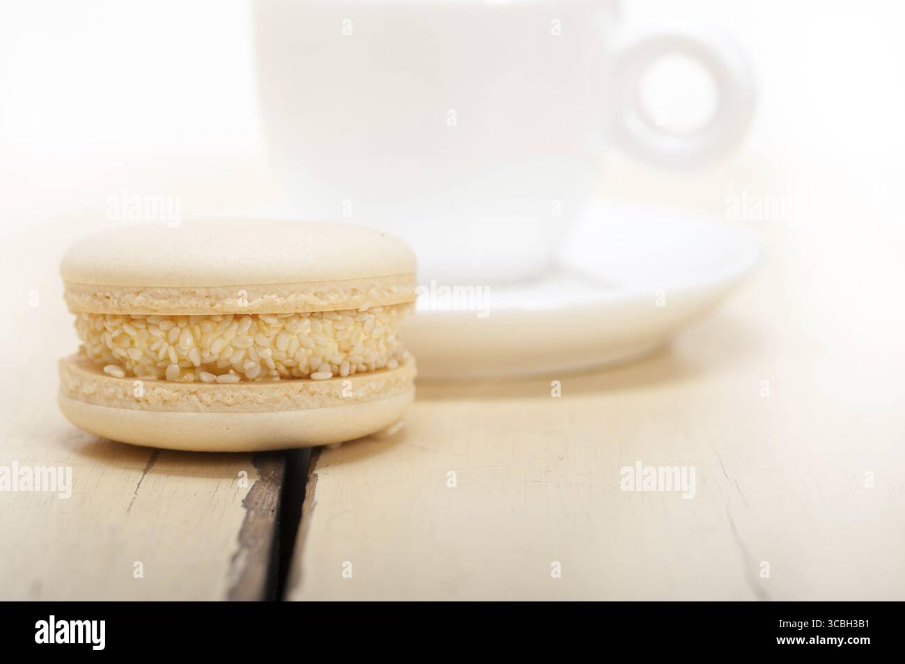 Macarons colorés avec café expresso sur table en bois blanc Banque D'Images