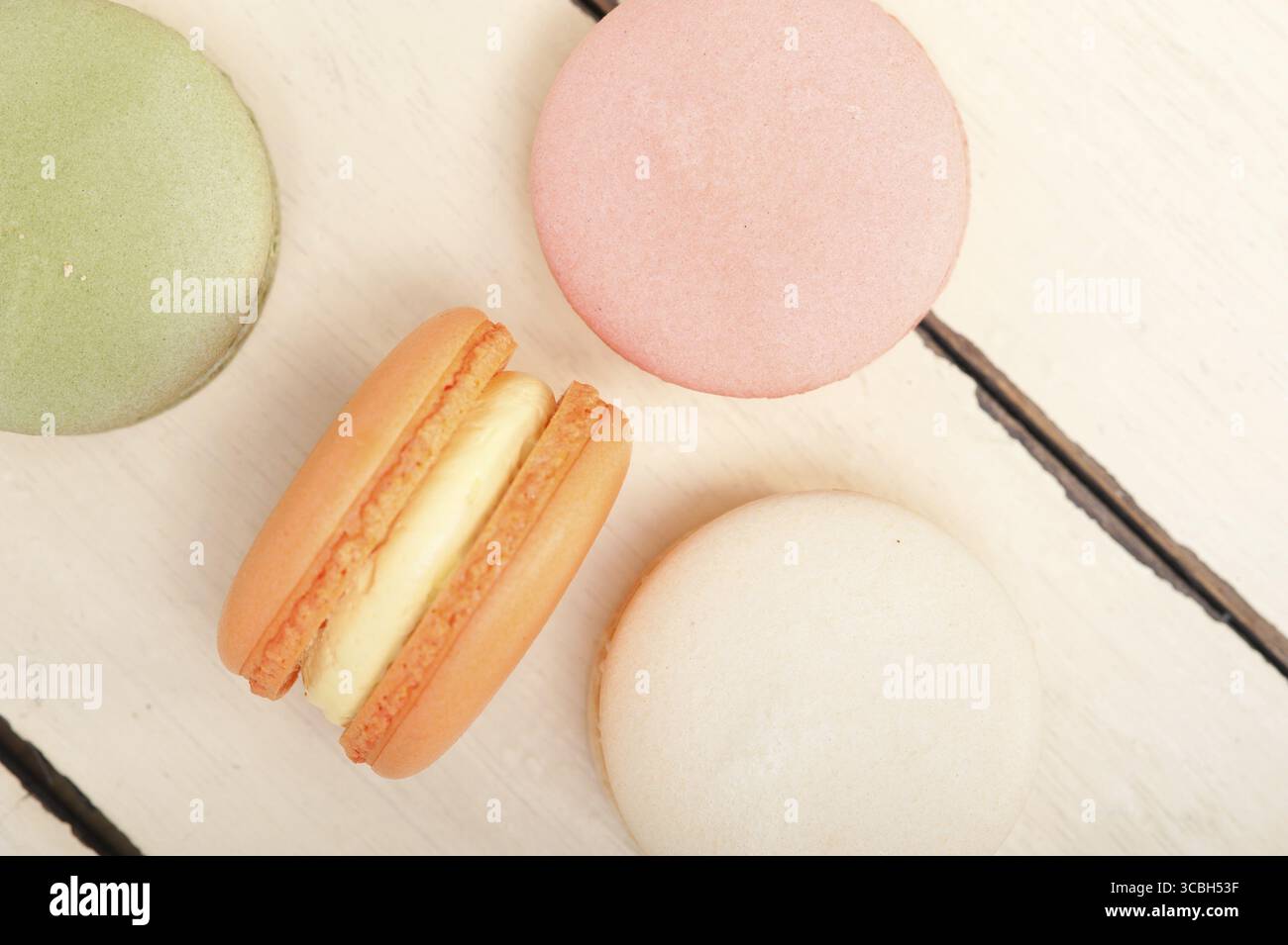 Macarons français colorés sur une table en bois rustique blanc Banque D'Images