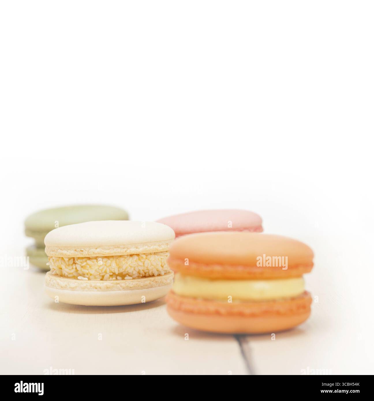Macarons français colorés sur une table en bois rustique blanc Banque D'Images