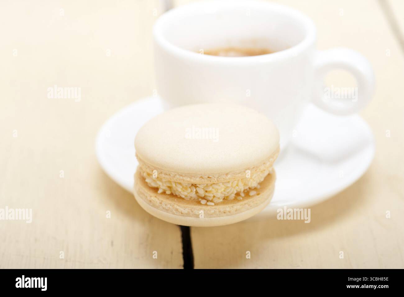 Macarons colorés avec café expresso sur table en bois blanc Banque D'Images
