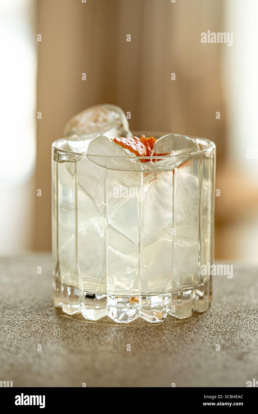 Gin et cocktail tonique avec glace dans un verre à facettes Banque D'Images