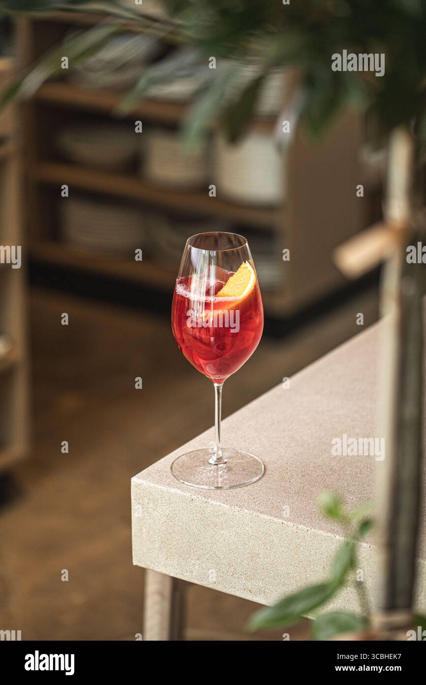 Cocktail rouge avec orange et glace dans un verre à vin Banque D'Images