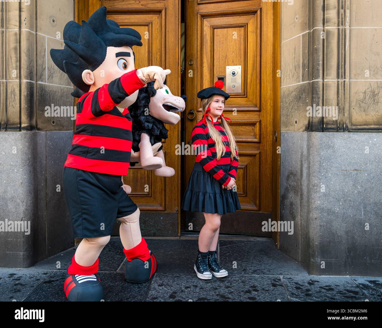 Dennis the menace & Girl habillés en Minnite the Minx célèbrent le centenaire de la Bibliothèque nationale d'Écosse, pont George IV, Édimbourg, Écosse, Royaume-Uni Banque D'Images