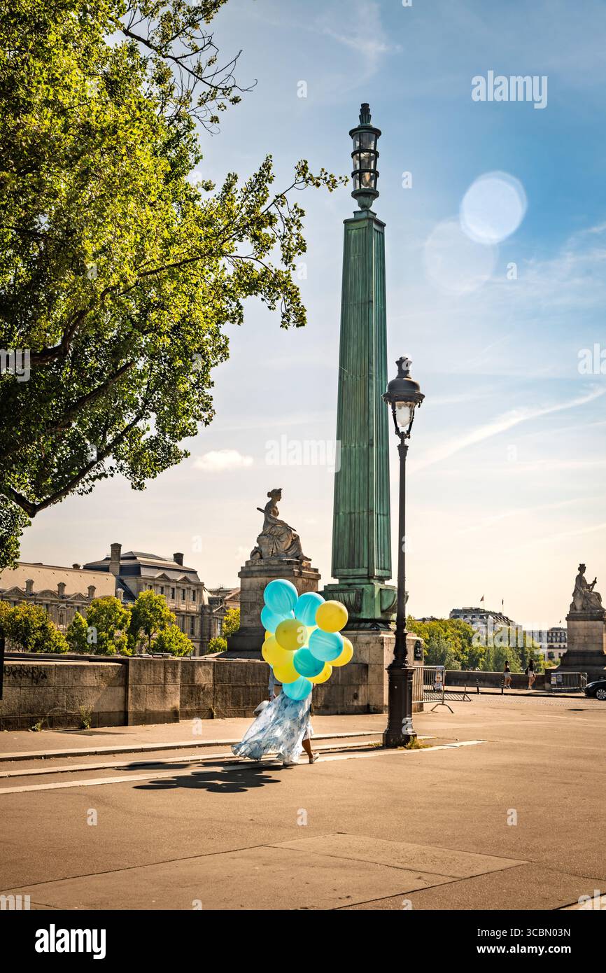 Femme tenant des ballons à Paris, France Banque D'Images