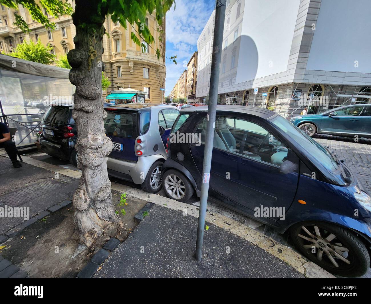Voitures minuscules parking perpendiculaire entre 2 voitures stationnées horizontalement à rome Banque D'Images