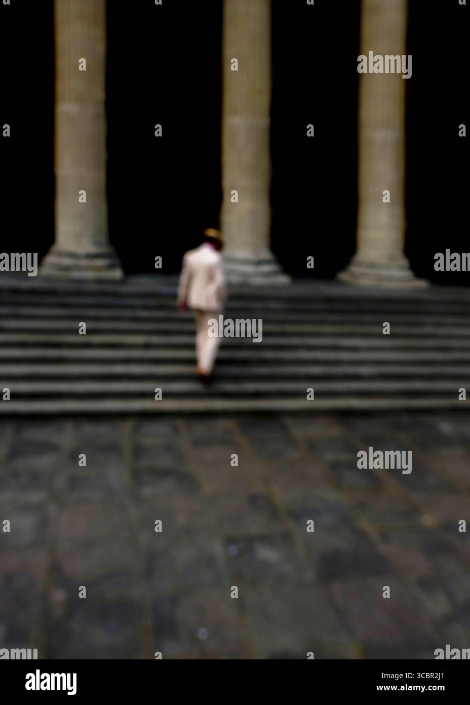 Une personne en costume monte un escalier. Banque D'Images
