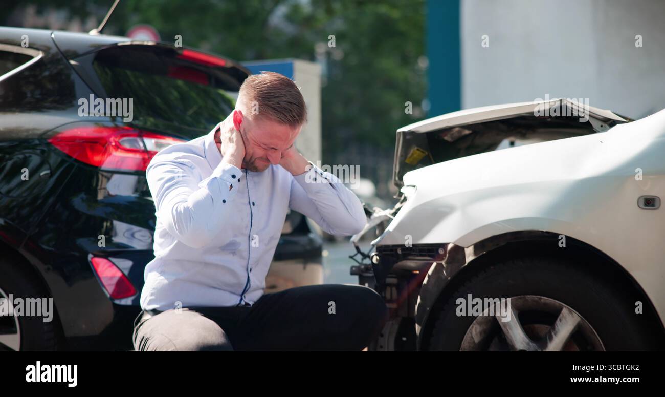 Le jeune conducteur masculin cherche l'aide juridique après blessure de voiture Whiplash. Banque D'Images