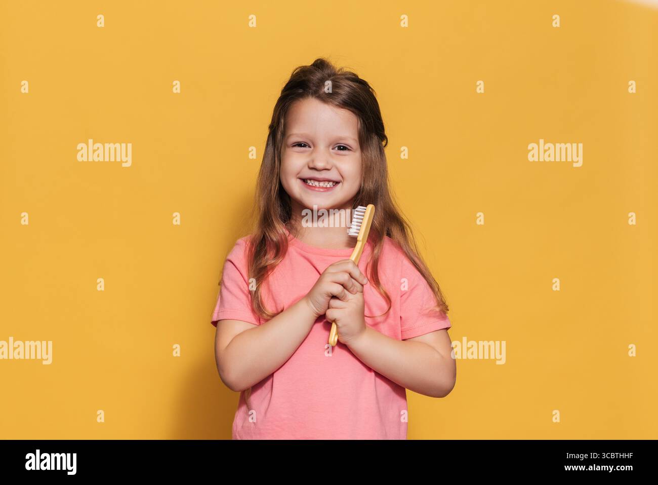 Une fille heureuse tient une brosse à dents dans ses mains. Un tir isolé. Odontologie pédiatrique Banque D'Images