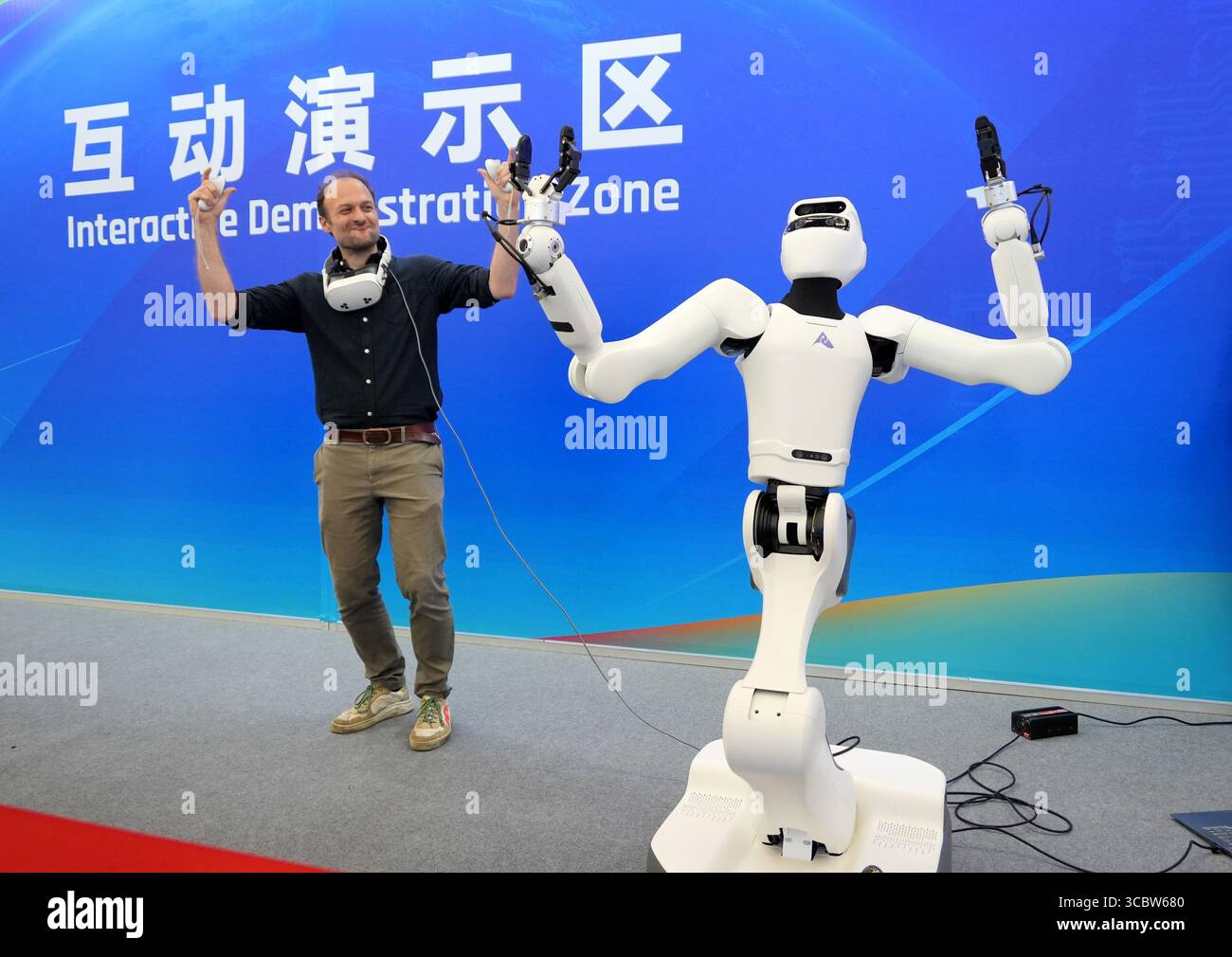 PÉKIN, CHINE - 8 AOÛT 2025 - Un visiteur étranger a expérimenté le modèle de fonctionnement du mouvement du corps entier et la fonction d'apprentissage du robot S1 lors de la Conférence mondiale des robots 2025 à Pékin, en Chine, le 8 août 2025. Banque D'Images