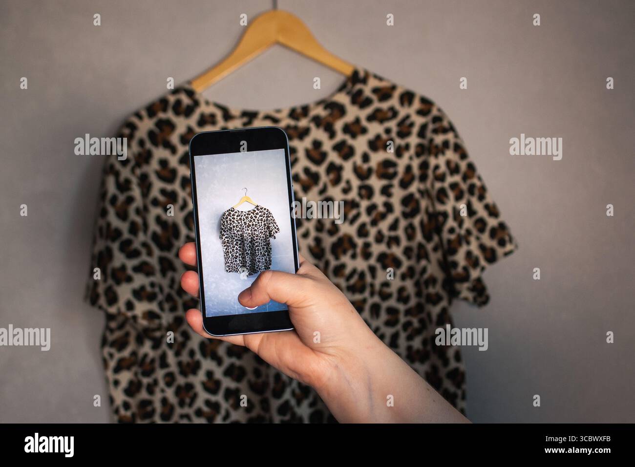 Fille prend des photos de ses vieux articles de garde-robe pour vendre d'occasion. Fond minimaliste. Concentrez-vous sur les habitudes de consommation respectueuses de l'environnement. Banque D'Images Fille prend des photos de ses vieux articles de garde-robe pour vendre d'occasion. Fond minimaliste. Concentrez-vous sur les habitudes de consommation respectueuses de l'environnement. Banque D'Images