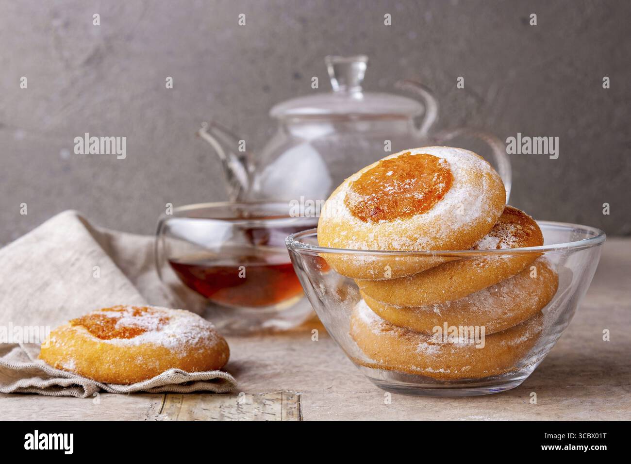 Des biscuits faits maison avec de la confiture d'orange se trouvent dans une assiette en verre sur la table Banque D'Images