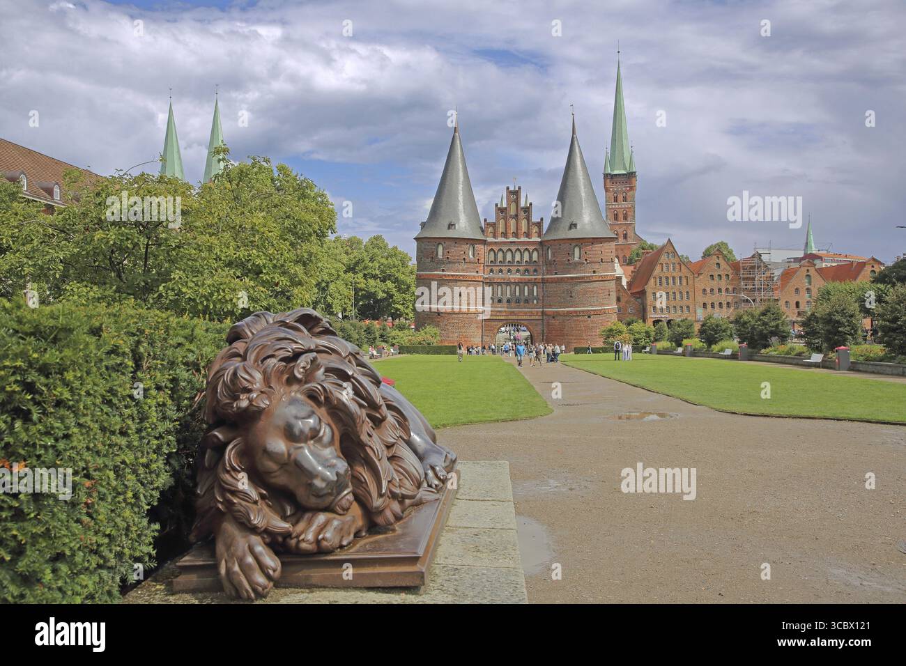 Figurine de lion endormi à l'historique Holstentor et membre de Peter's Church Tower à Luebeck, Brick Gothic, Brick Building, City Gate, Landmark, Holstentor Banque D'Images