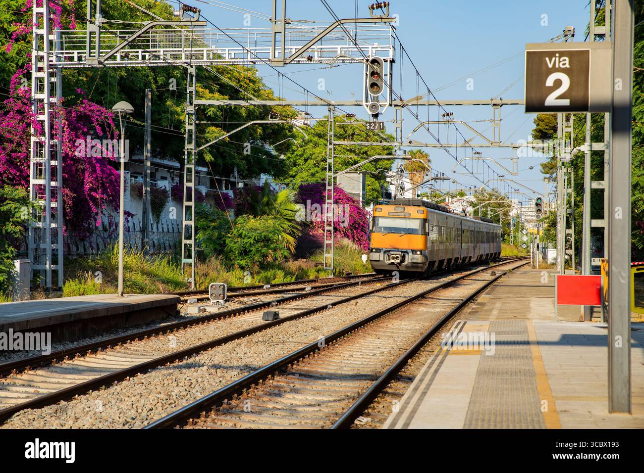 Des voies ferrées et un train sur fond de végétation colorée. Voyage en train en Espagne Banque D'Images
