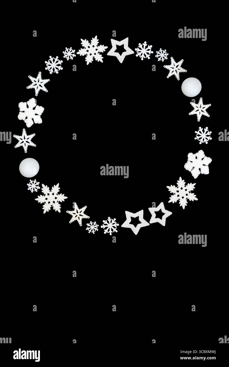 Couronne de Noël flocon de neige blanc, étoile, décorations en forme de boule sur fond noir. Guirlande fantaisie dépolie pour les fêtes de Noël. Banque D'Images