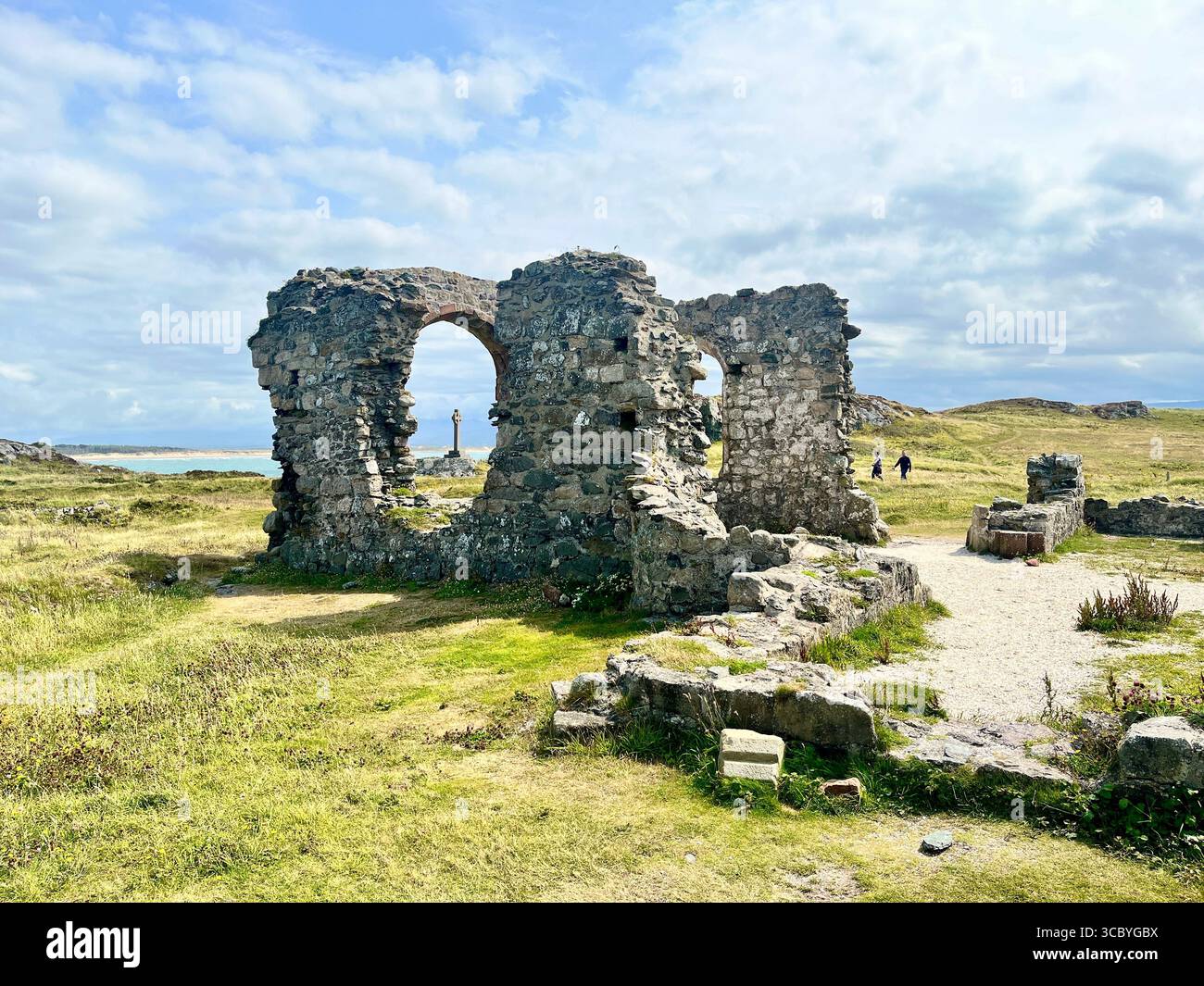 Les ruines de l'église St Dwynwens sur l'île de Llanddwyn au large d'Anglesey avec une croix celtique en arrière-plan. Saint Dwynwen est une princesse galloise du Ve siècle - Image de stock capturée avec un smartphone