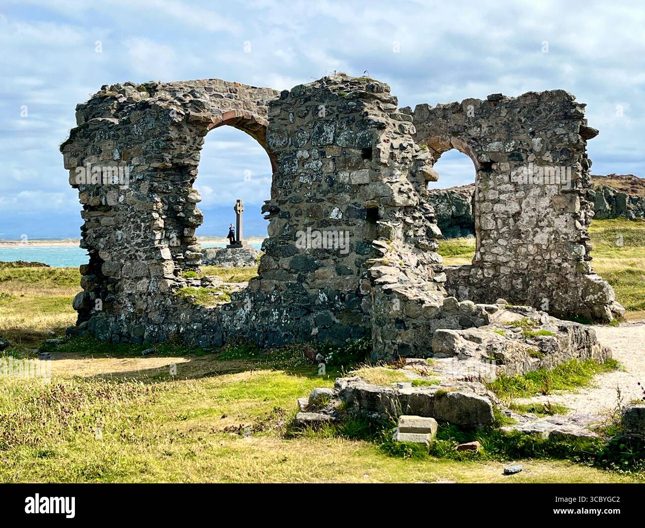 Les ruines de l'église St Dwynwens sur l'île de Llanddwyn au large d'Anglesey avec une croix celtique en arrière-plan. Saint Dwynwen est une princesse galloise du Ve siècle - Image de stock capturée avec un smartphone
