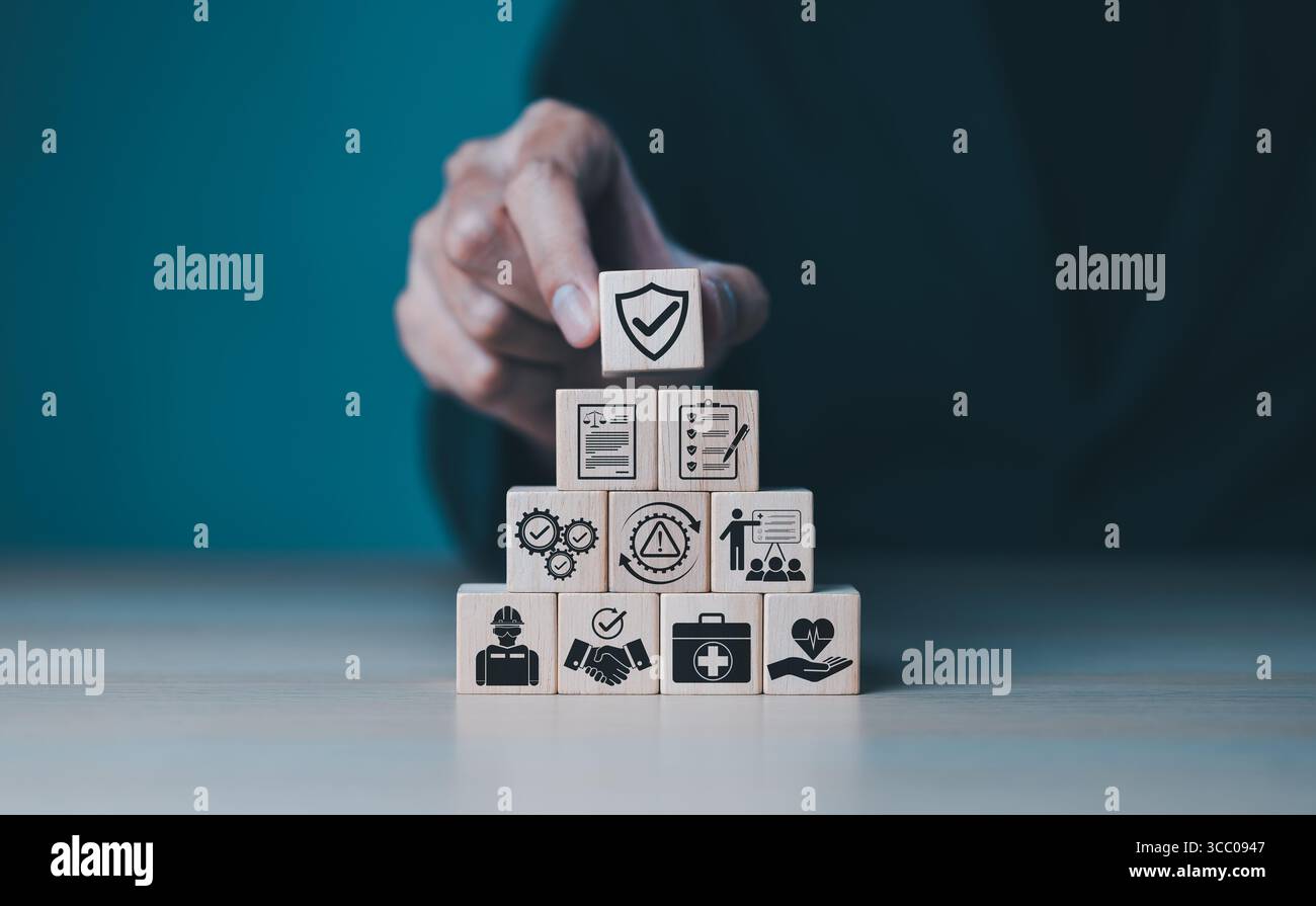 Concept de sécurité et de conformité au travail. Disposer des blocs de bois, icônes liées à la sécurité, conformité, santé, inspection, formation, protection, réglementation, Banque D'Images