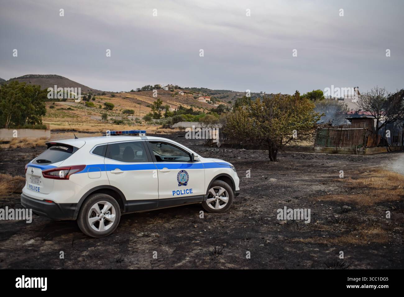 Keratea, Attique, Grèce, 8 août 2025. Une voiture de police est garée devant un vieux bâtiment incendié où un homme a été retrouvé mort lors d'un incendie dans la région de Keratea, Attique, près d'Athènes. Au moins une vie perdue lors d'un grand feu de forêt qui a échappé à tout contrôle près des villages et s'est dirigé vers le sud, attisée par des vents très forts. Crédit : Dimitris Aspiotis/Alamy Live News Banque D'Images