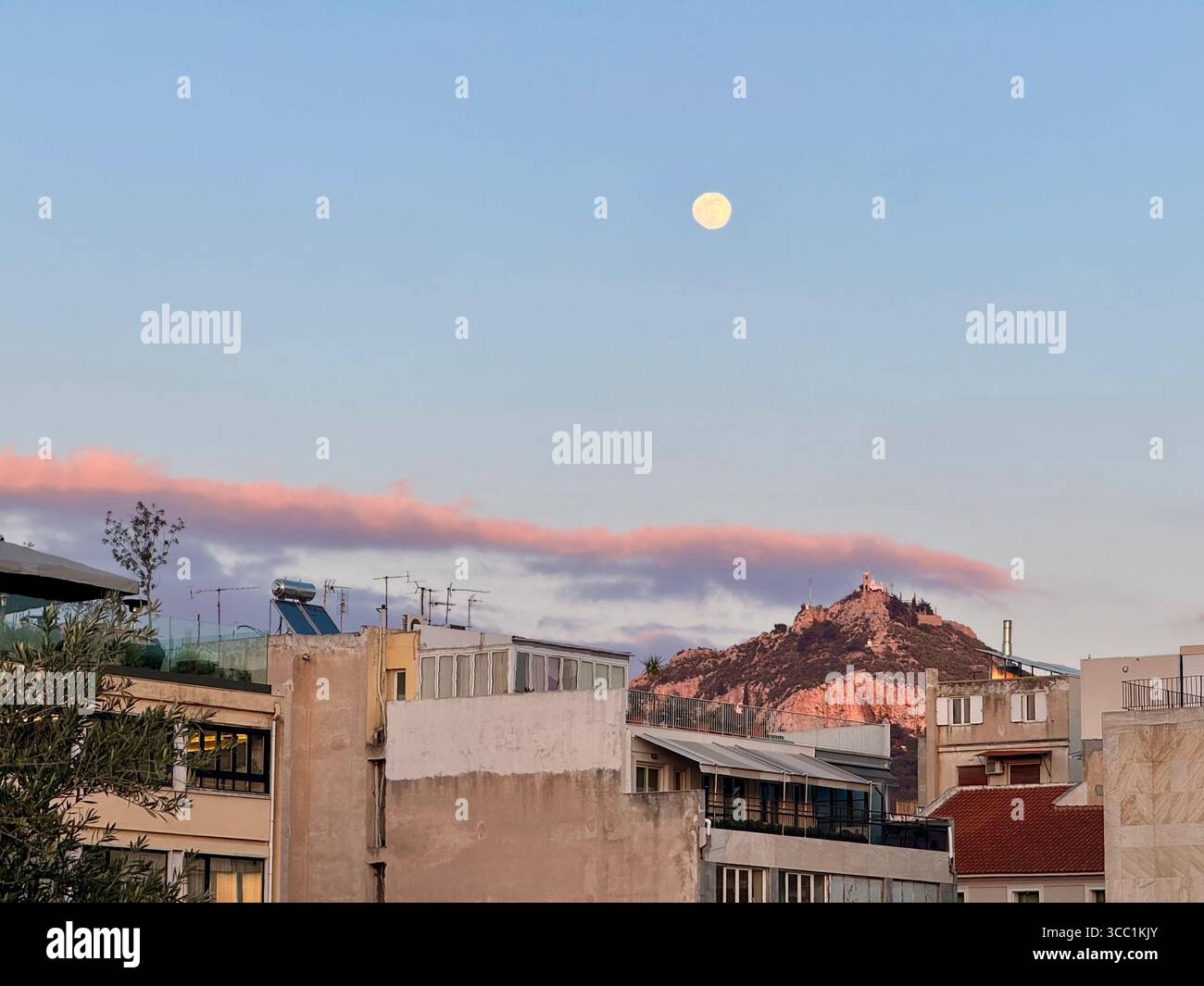 Vue sur le toit du paysage urbain d'Athènes au coucher du soleil avec la montagne Lycabette en arrière-plan. - Image de stock capturée avec un smartphone