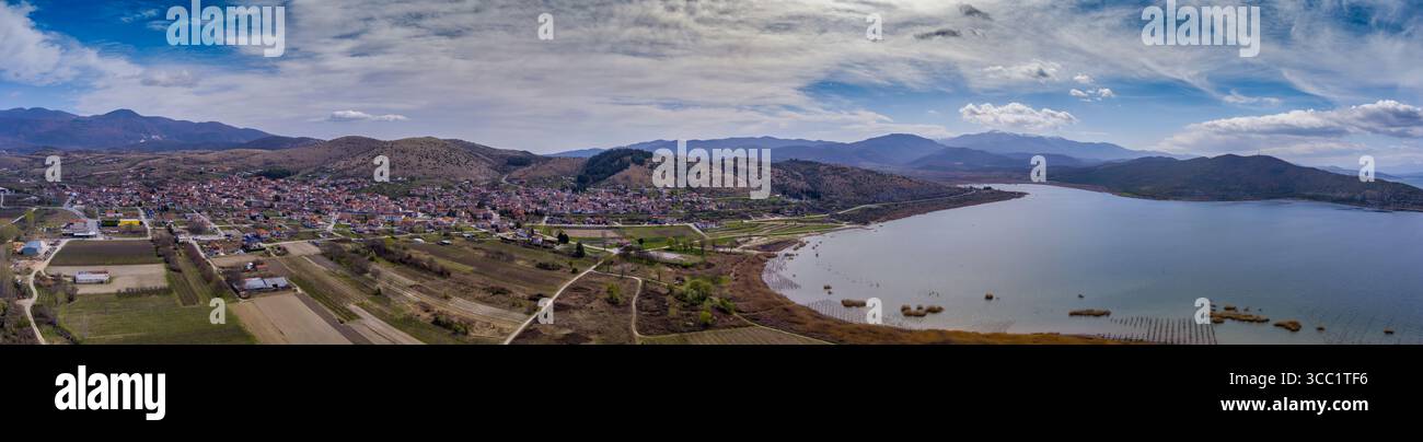 Vue aérienne d'Arnissa, Grèce, avec le lac Vegoritida à côté de la ville. Entouré de collines et de montagnes, ce paysage paisible mélange nature et tra Banque D'Images