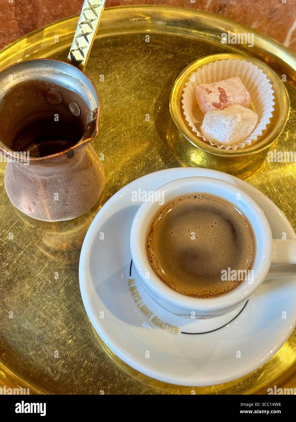 Café grec infusé traditionnellement sur du sable chaud à l'aide d'un pot en cuivre, une méthode de préparation unique et authentique. Banque D'Images