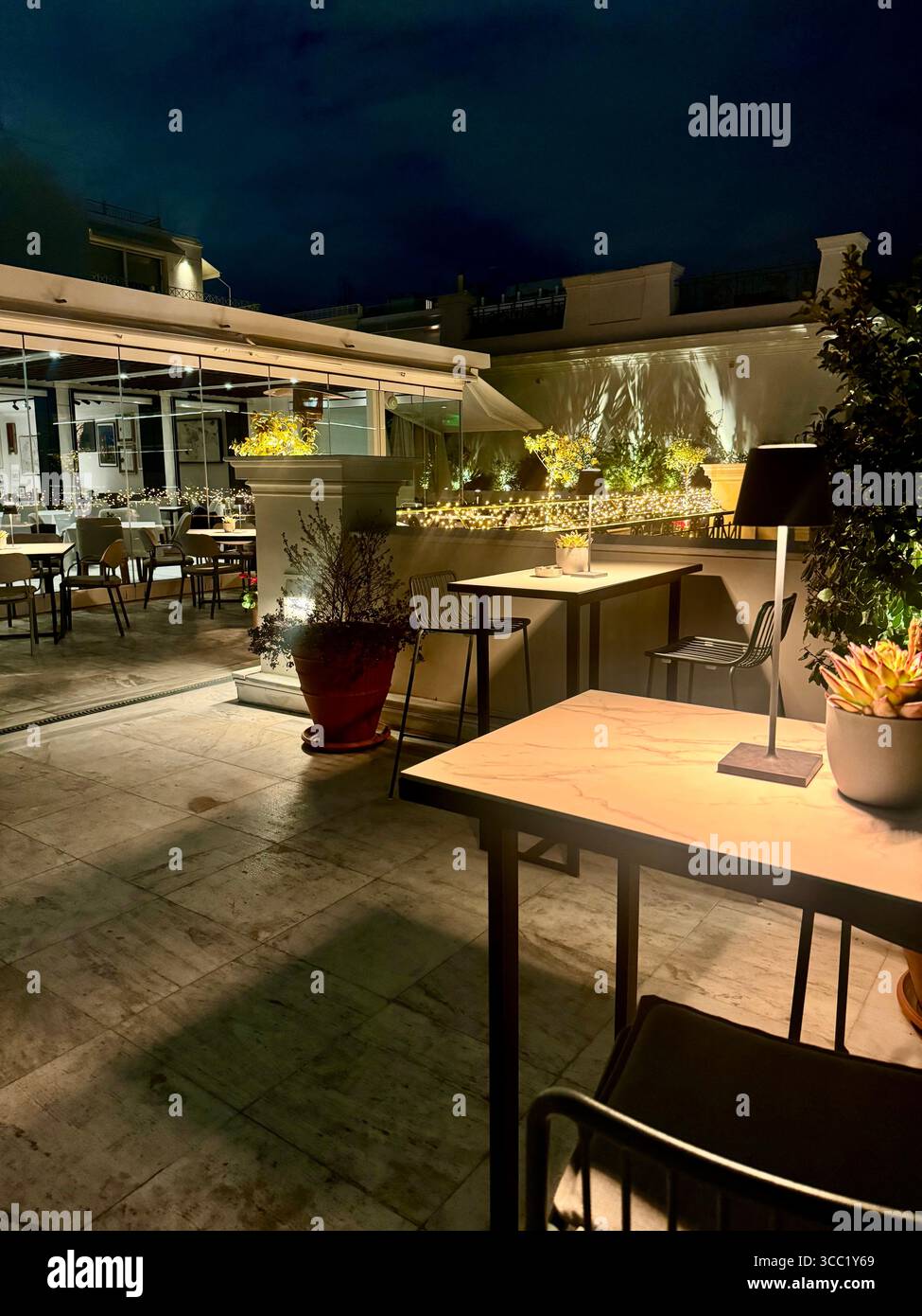 Vue nocturne sur le toit-terrasse du Museu Benaki à Athènes, dotée de sièges extérieurs et d'un éclairage d'ambiance. Banque D'Images