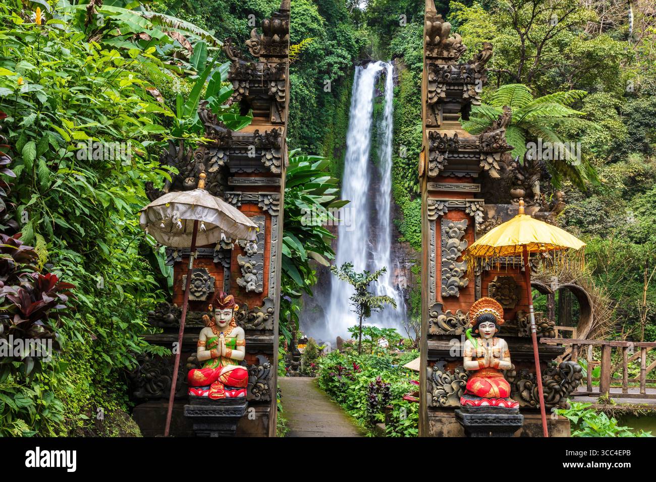 Cascade de Gitgit dans le nord de Bali, flanquée par les statues à l'entrée, façonné dans un design balinais traditionnel. Banque D'Images