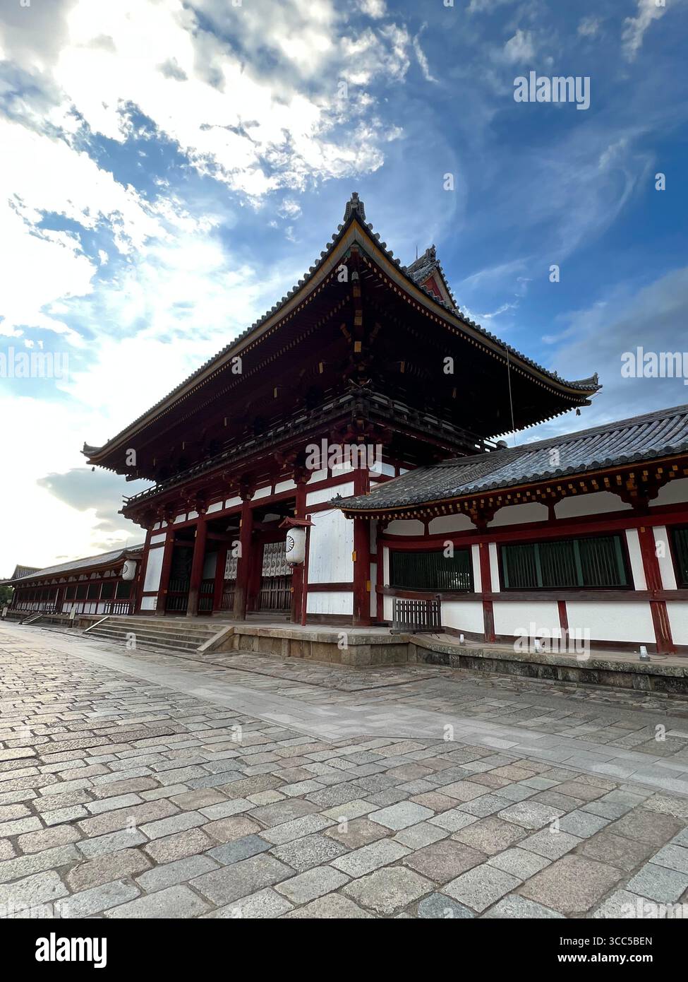 Bâtiment traditionnel du temple dans le parc de Nara, au Japon, avec une architecture en bois rouge et blanc sous un ciel bleu vif. Banque D'Images