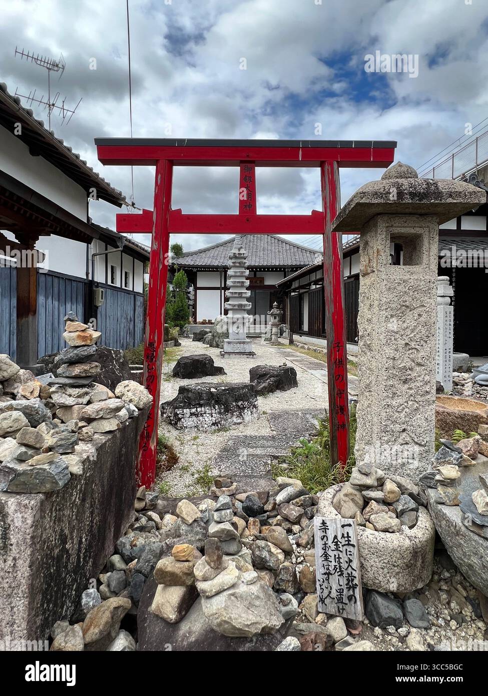 Un ruisseau urbain étroit qui traverse un quartier résidentiel de Kyoto, au Japon, sous un ciel couvert. Banque D'Images