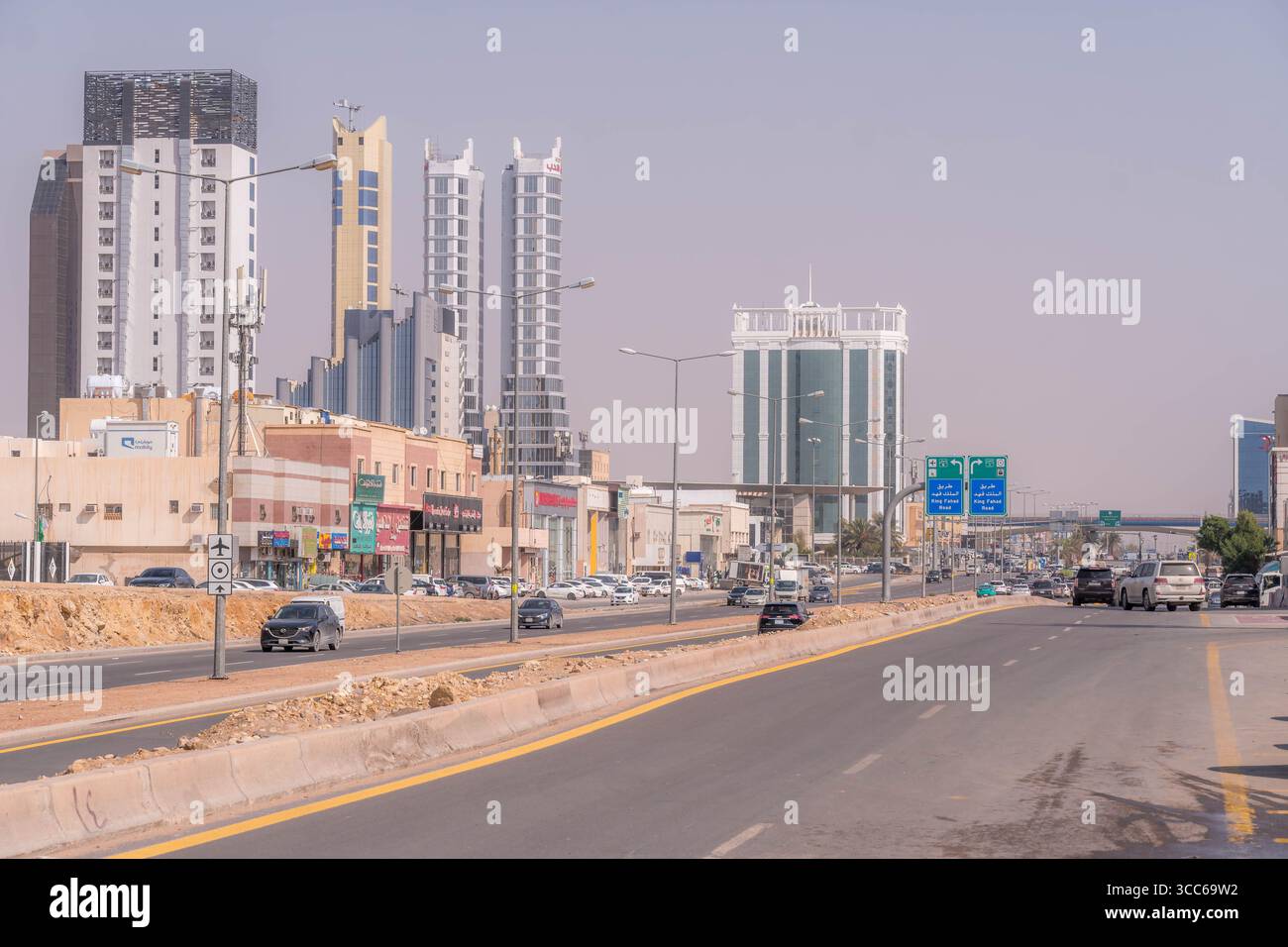 Rue de la ville à Riyad, en Arabie Saoudite, avec la population locale et la circulation des voitures en semaine capturant la vie urbaine quotidienne et les mouvements. Banque D'Images