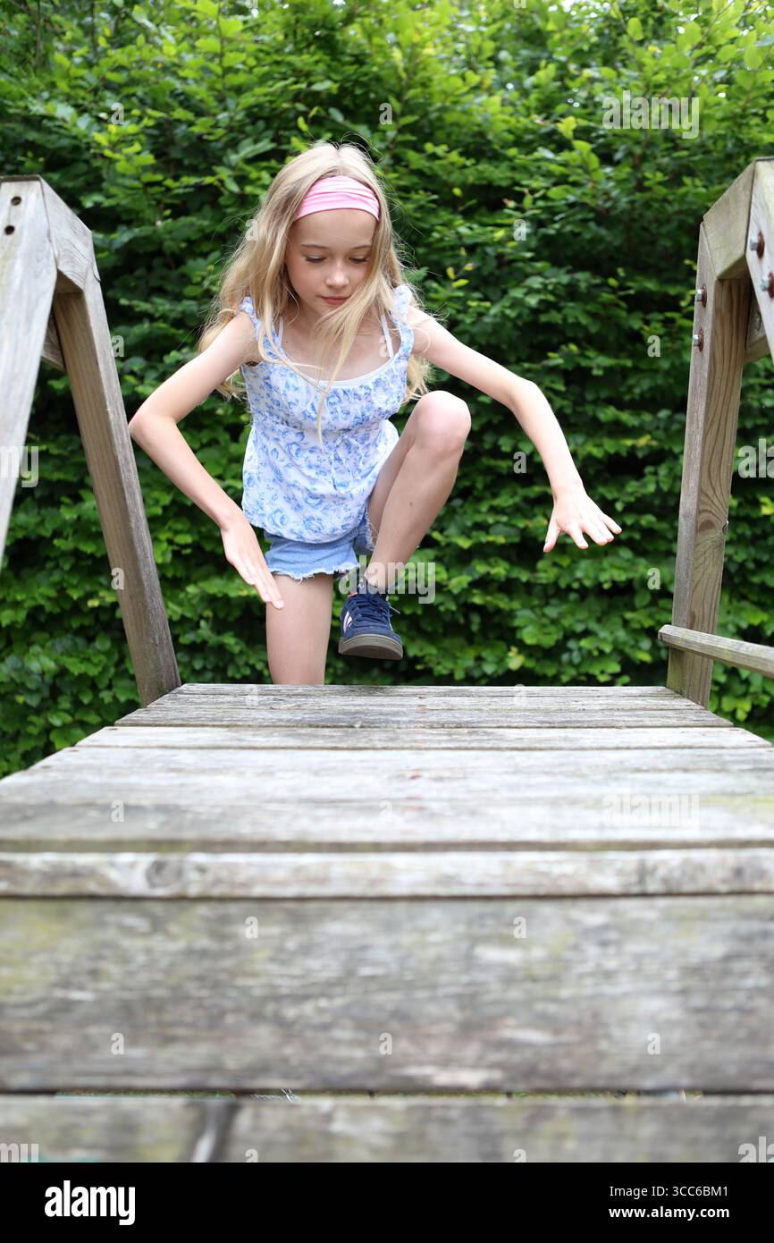 Fille grimpe sur le cadre d'escalade en bois Banque D'Images