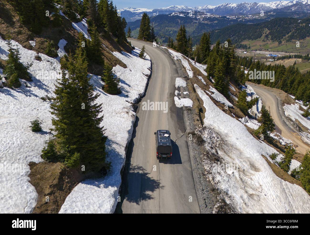 Voiture sur route de montagne sinueuse, entourée de neige et de sapins, avec vue large, vue aérienne, camping-car, camping-car, sur le chemin de Goderdzi Pass, Adjara Re Banque D'Images