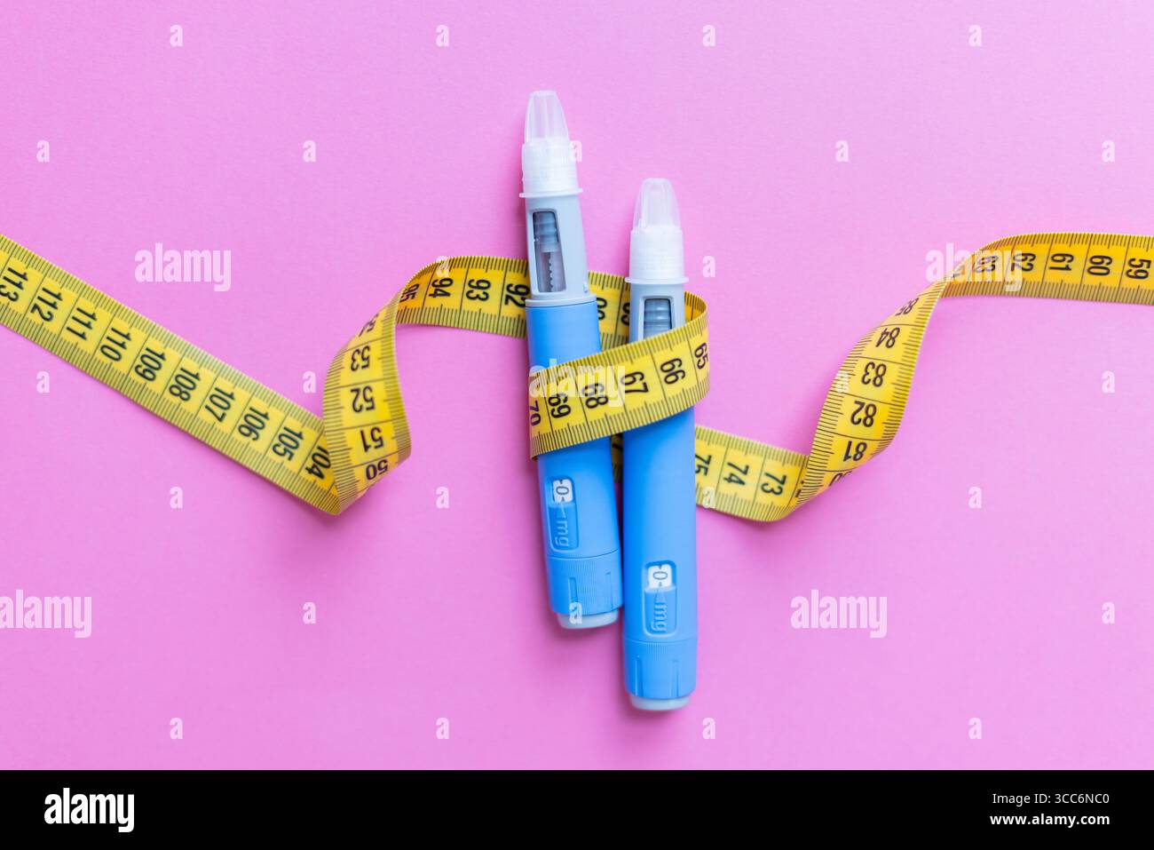 Stylos médicaux pour la thérapie Ozempic sur fond rose. Illustrer les solutions modernes pour le traitement des maladies chroniques. Gros plan sur la perte de poids et le diabète Banque D'Images
