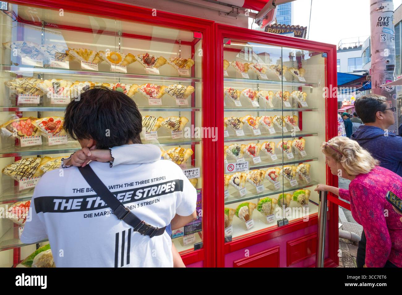 Les gens regardant le menu des modèles de nourriture shokuhin sampuru à Marion Crêpes Takeshitadori Creperie, Takeshita Street, Harajuku, Jingumae, Shibuya City, Tokyo Banque D'Images