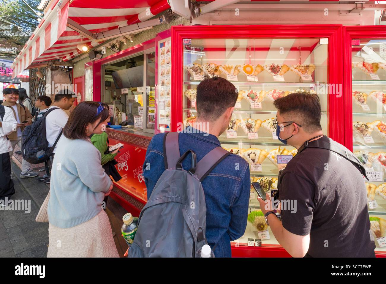 Hommes regardant le menu des modèles de nourriture shokuhin sampuru à Marion Crêpes Takeshitadori Creperie, Takeshita Street, Harajuku, Jingumae, Shibuya City, Tokyo, K. Banque D'Images