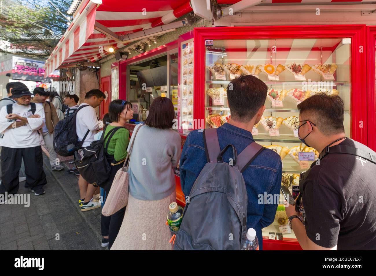 Hommes regardant le menu des modèles de nourriture shokuhin sampuru à Marion Crêpes Takeshitadori Creperie, Takeshita Street, Harajuku, Jingumae, Shibuya City, Tokyo, K. Banque D'Images