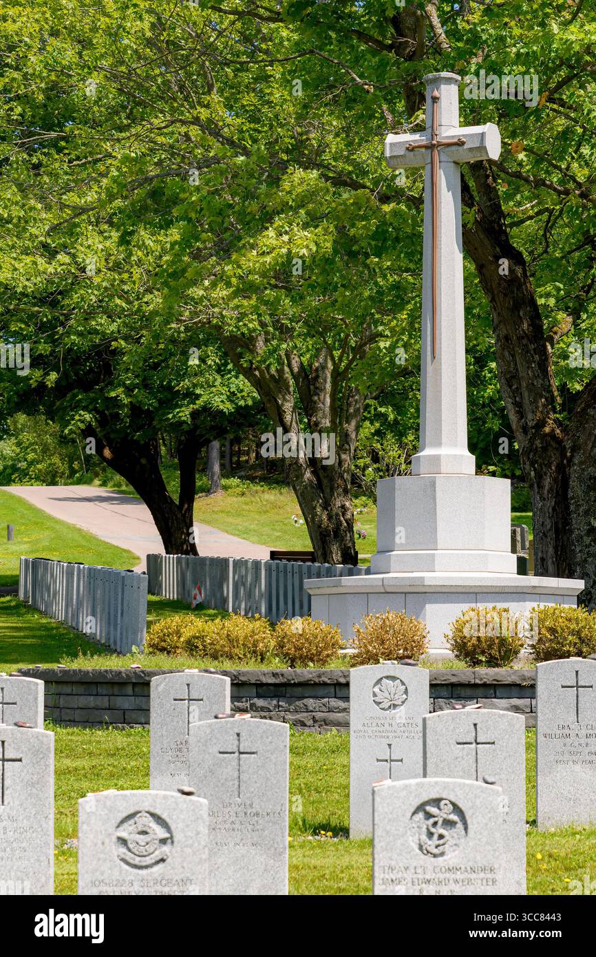 Saint John, N.-B., Canada - 21 juin 2025 : section militaire d'un cimetière canadien. Une grande croix se dresse comme un monument en arrière-plan. Banque D'Images